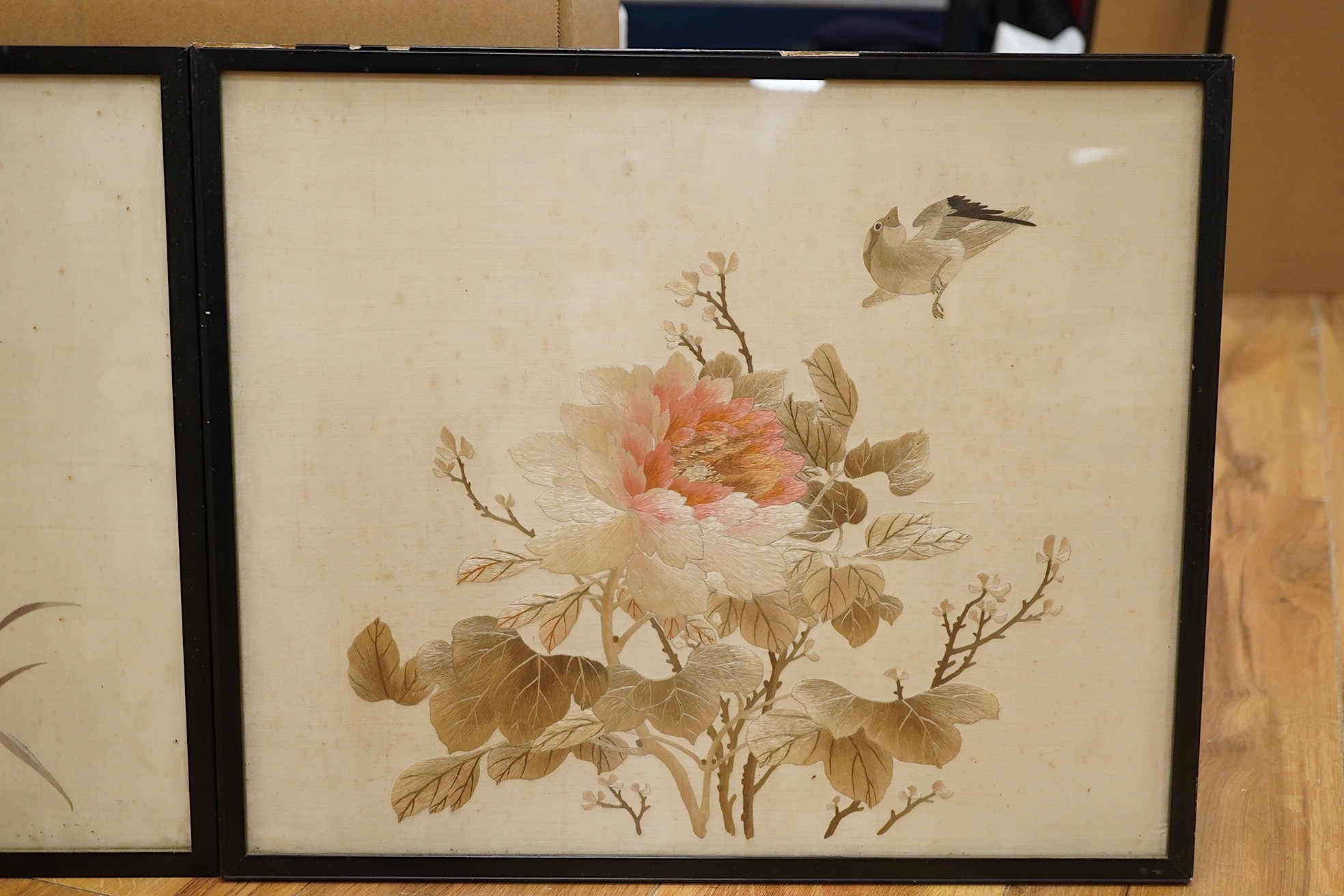 Two early 20th century Japanese cream silk polychromes embroidered panels of flowers birds and butterflies, largest 45cm wide x 37cm high. Condition - there are marks on the cream silk, which may be able to be profession